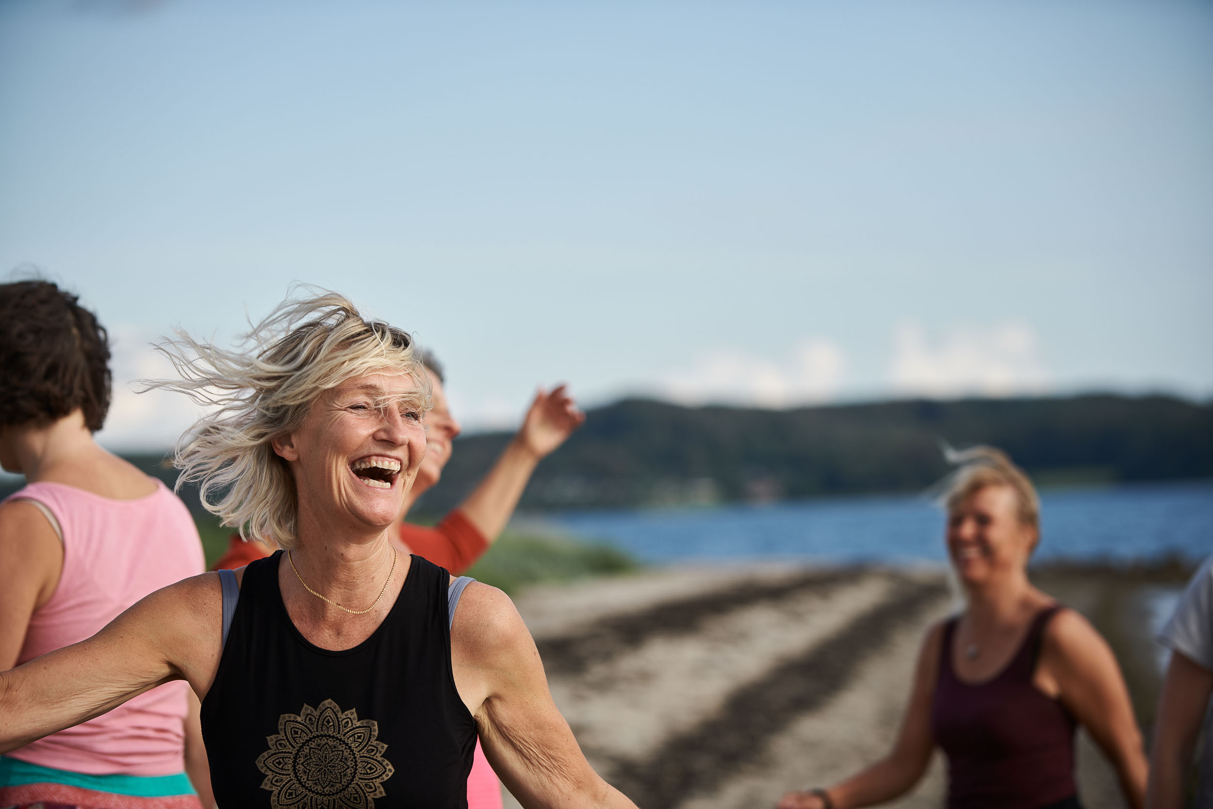 Dorthe Broeng griner under shaking meditation ved fjorden